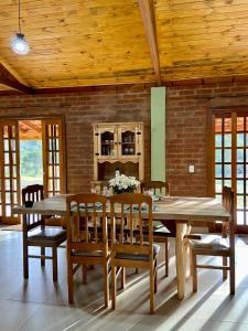 a dining room with a wooden table and chairs at Villagio Angatu in Santo Antônio do Pinhal