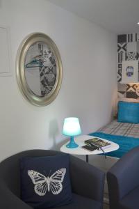ein Wohnzimmer mit einem Schmetterlingskissen auf einem Stuhl und einer Uhr in der Unterkunft Alfama Lisbon Studio in Lissabon