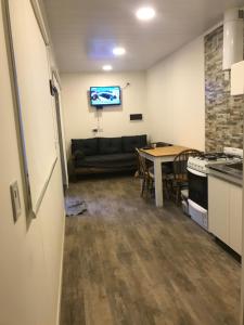 eine Küche und ein Esszimmer mit einem Tisch und einer Couch in der Unterkunft Los Amancay del Otto ventana in San Carlos de Bariloche + 15 Fotos