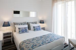 ein Schlafzimmer mit einem großen Bett mit blauen und weißen Kissen in der Unterkunft Marino Lisboa Boutique Guest House in Lissabon