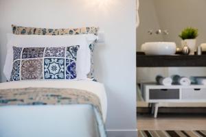リスボンにあるMarino Lisboa Boutique Guest Houseのベッドルーム1室(青と白の枕が備わるベッド1台付)