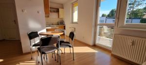 a kitchen with chairs and a table and a window at Apartament 200 m do morza in Kołobrzeg