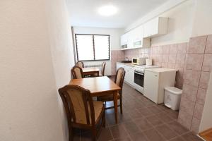 una pequeña cocina con mesa de madera y sillas en Hostel Sobe Drvorez, en Banja Luka