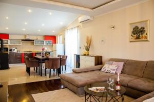 salon i kuchnia z kanapą i stołem w obiekcie Apartments Kraljic w mieście Zadar