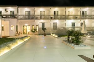 a large white building with a courtyard at night at Elektra Comfort Hotel in Skala Prinou