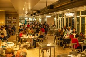 un grupo de personas sentadas en mesas en un restaurante en Marina del Faro Resort en Termas de Río Hondo