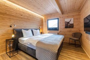 A bed or beds in a room at Bergwaldchalets Wellness