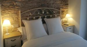 a bedroom with a bed with two night stands and two lamps at Las Rocas in Vega de Valcarce