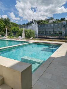 a swimming pool with a fountain in the background at Hotel Vouga in Termas de Sao Pedro do Sul