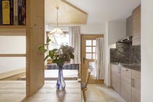 une cuisine avec un vase de fleurs sur une table dans l'établissement Apartment Ciasa Laoi, à San Cassiano