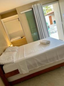 um quarto com uma cama grande e um espelho em Chalés Sol de Milagres em São Miguel dos Milagres