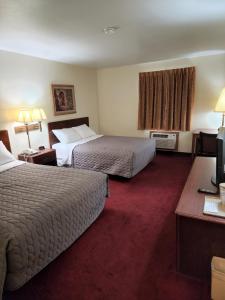 a hotel room with two beds and a desk at Family Budget Inn in Bethany