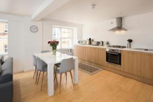 a kitchen with a white table and chairs in a room at North Laine City Centre sleeps 6 in Brighton & Hove