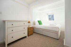 a bedroom with a white bed and a dresser at North Laine City Centre sleeps 6 in Brighton & Hove
