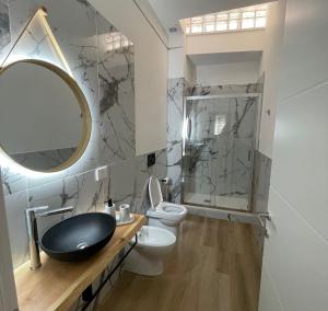 bagno con lavandino, servizi igienici e specchio di Maison Aida a Porto SantʼElpidio