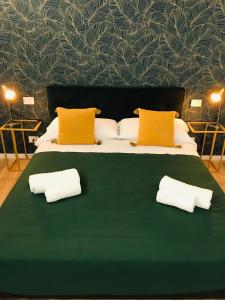 un grande letto verde con due cuscini sopra di Maison Aida a Porto SantʼElpidio