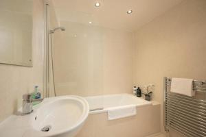 y baño blanco con lavabo y ducha. en North Laine City Centre sleeps 6 en Brighton & Hove