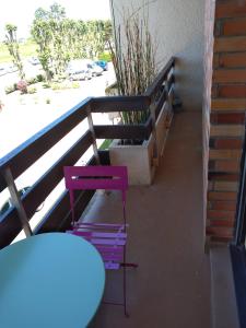 d'une table et de chaises violettes sur un balcon. dans l'établissement Le petit Cabourgeais, à Cabourg