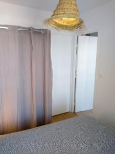- une chambre avec deux portes, un lit et un panier dans l'établissement Le petit Cabourgeais, à Cabourg