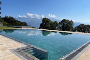 a swimming pool with mountains in the background at Les Terrasses de Lavaux 1 - Appartement de luxe avec vue panoramique et piscine in Puidoux