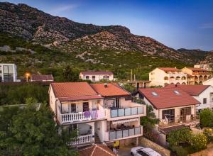 a group of houses with a mountain in the background at Apartments Julia & Nika in Karlobag