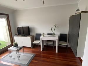 Apartamento Aldán - Vilariño في كانجاس دي مورازو: غرفة معيشة مع طاولة وكراسي بيضاء