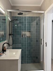 a green tiled bathroom with a shower and a sink at A Casa Branca in Mértola +19 photos