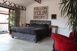 una camera con letto e sedia rossa di Grand loft de charme, place du village à Thuir a Thuir