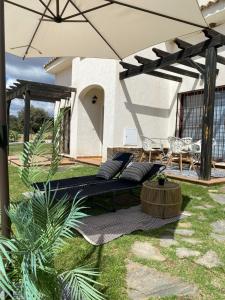 a patio with a couch under an umbrella at El Capricho in El Ronquillo