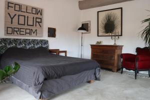 una camera con letto e sedia rossa di Grand loft de charme, place du village à Thuir a Thuir