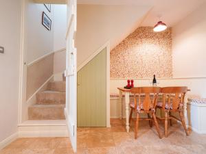 a dining room with a table and a staircase at Cloudberry Cottage in Stanton in Peak