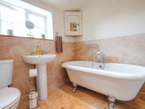 ein Badezimmer mit Badewanne, Waschbecken und Toilette in der Unterkunft Cloudberry Cottage in Stanton in Peak + 19 Fotos