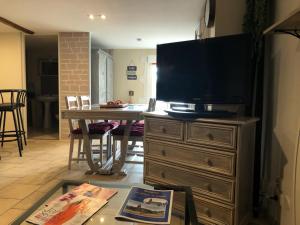 a living room with a television on top of a dresser at les Quatre Vents in Bragny-sur-Saône