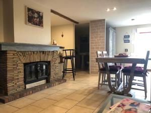 a living room with a brick fireplace and a table at les Quatre Vents in Bragny-sur-Saône