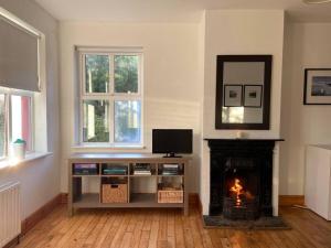 ein Wohnzimmer mit einem Kamin, einem TV und einem Kamin in der Unterkunft 1 Keelkyle Cottage Connemara Letterfrack County Galway in Letterfrack