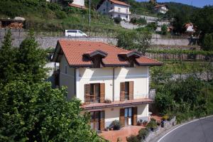 a white house with a red roof on a hill at The Sweet Garret in Agerola