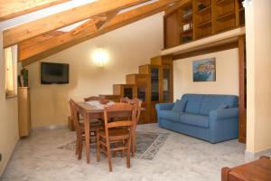 un soggiorno con un tavolo e un divano blu di The Sweet Garret ad Agerola