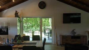a dining room with a table and a clock on the wall at Haus DeMa in Walkenried