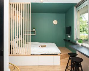 a bedroom with green walls and a bed with stools at Le lodge de Fourvière in Lyon