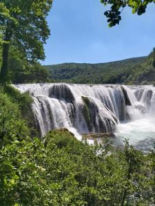 einem Wasserfall in der Mitte eines Flusses in der Unterkunft Apartman ALADIN in Bihać