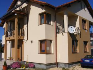 a house with a clock on the side of it at Pensiunea Queen Mary in Sînpetru