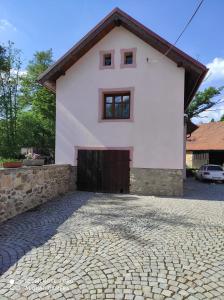 uma casa branca com uma entrada de tijolos em Příjemné ubytování na farmě 