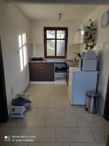 uma cozinha com um frigorífico branco e piso em azulejo em Příjemné ubytování na farmě 