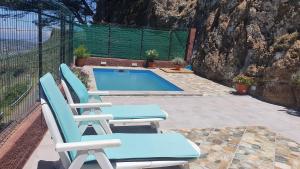 a pair of chairs and a swimming pool at Casa Cueva Paquito in Vega de San Mateo