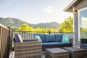 um pátio com um sofá azul e cadeiras de vime em Modern Golden Cottage with Incredible Mountain View! em Golden