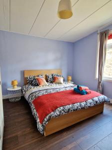 a bedroom with a bed with a red blanket at Three Bridges Waterfront in North Queensferry