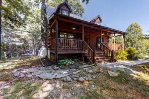a log cabin in the woods with a porch and stairs at Hoof Haven in New Tazewell