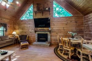 a living room with a fireplace in a log cabin at Hoof Haven in New Tazewell