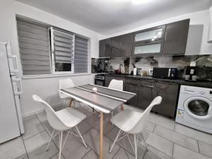 eine Küche mit einem Tisch und weißen Stühlen in der Unterkunft Blue Star STUDIO in Craiova