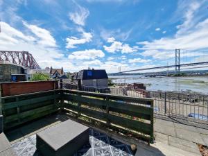 a view of a bridge over a river with a bench at Three Bridges Waterfront in North Queensferry